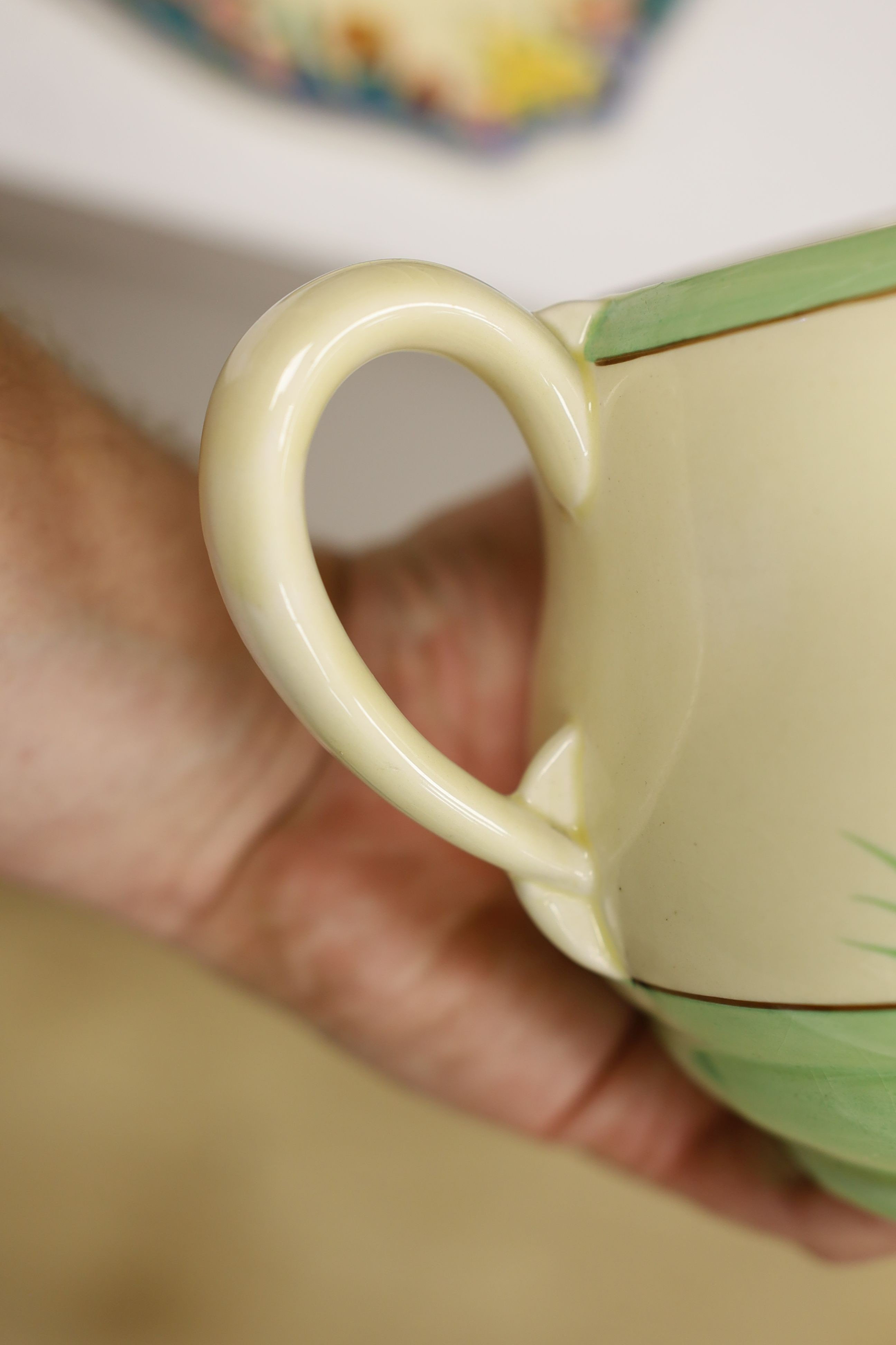 A Clarice Cliff crocus design milk jug and a Bizarre patterned side plate, jug 11.5 cms high